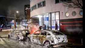 Dos vehículos de policía carbonizados tras los disturbios en La Haya