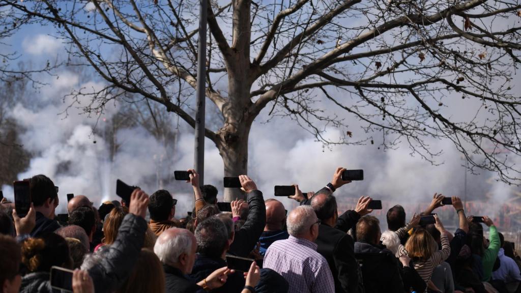 Varias personas graban la mascletá, este domingo, en Madrid.