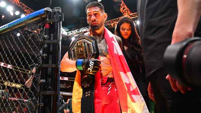 Ilia Topuria sale de la jaula acompañado de su novia, Giorgina Uzcategui, tras proclamarse campeón en la UFC