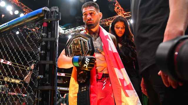 Ilia Topuria sale de la jaula acompañado de su novia, Giorgina Uzcategui, tras proclamarse campeón en la UFC