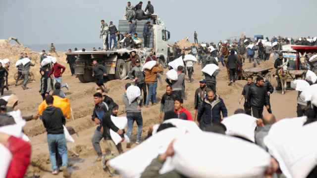 Palestinos recogen sacos de ayuda en una zona de seguridad en Gaza City antes de ir a Rafah.