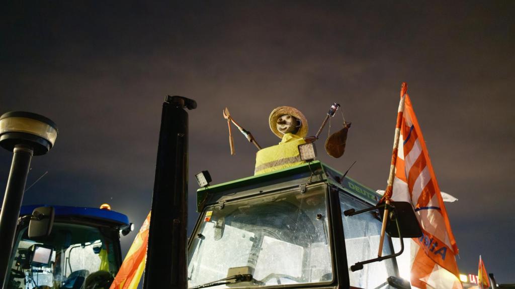 Un tractor coronado con un espantapájaros