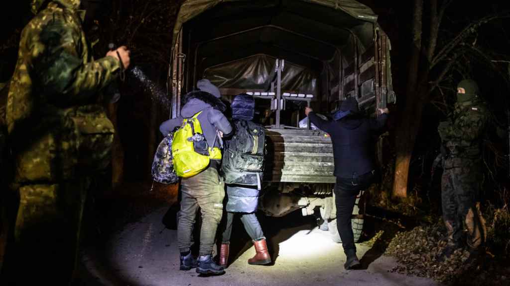 Una familia kurda de Irak es obligada a subirse a un camión militar en la ciudad polaca de Narewka.