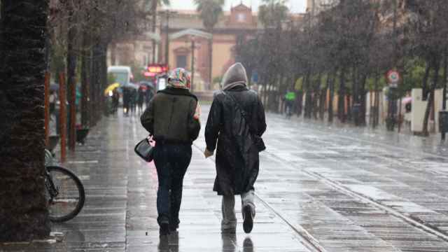 Dos personas pasean por la calle San Fernando bajo la lluvia de la borrasca 'Karlotta'.
