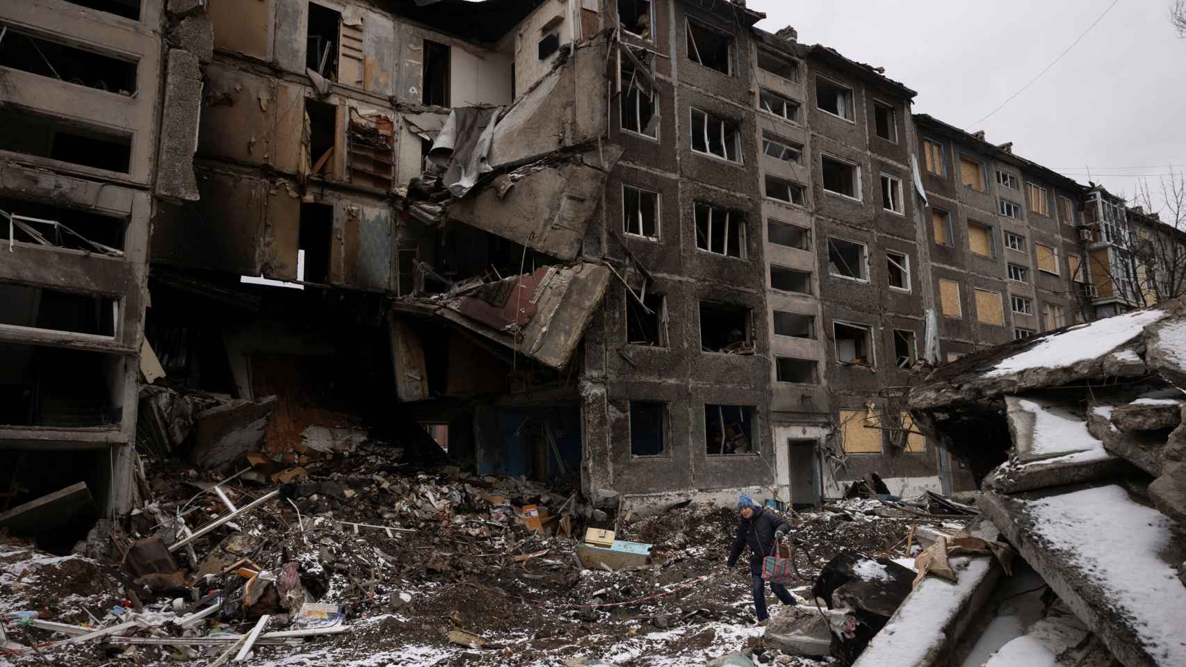 Una mujer pasa por bloques de apartamentos que fueron destruidos en un ataque con misiles rusos en Selydove, cerca de Avdiivka.