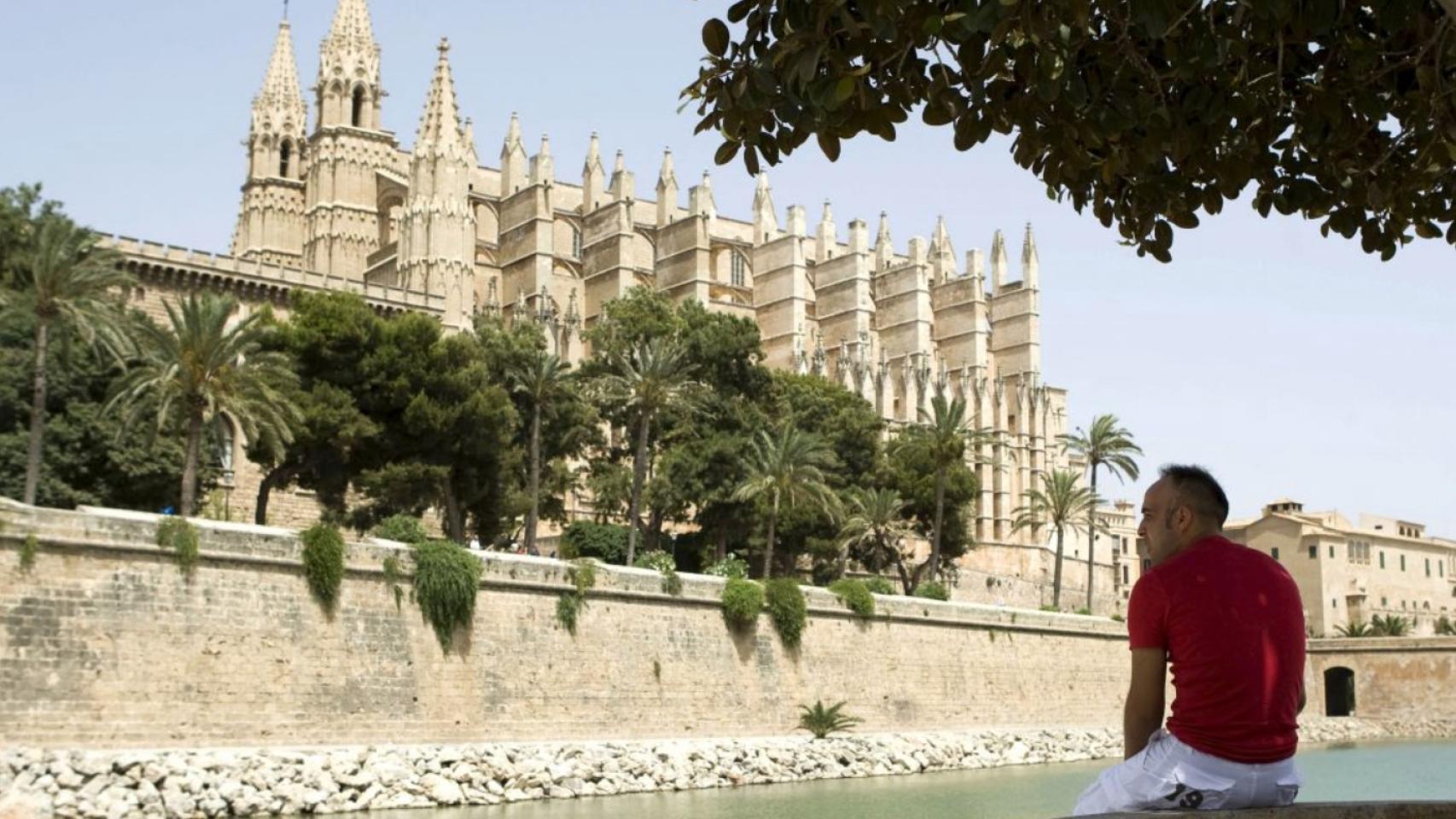 Imagen de un turista frente a la catedral de Palma de Mallorca.