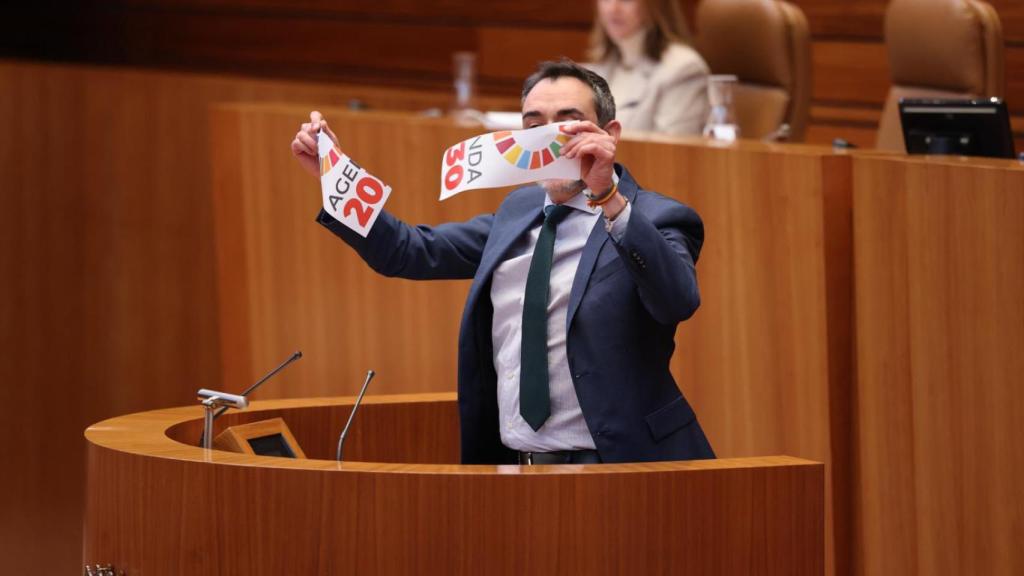 El procurador de Vox David Hierro rompe un cartel con el logo de la Agenda 2030 en el pleno de las Cortes de este miércoles.
