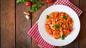 Un plato de pasta con salsa de tomate y langostinos