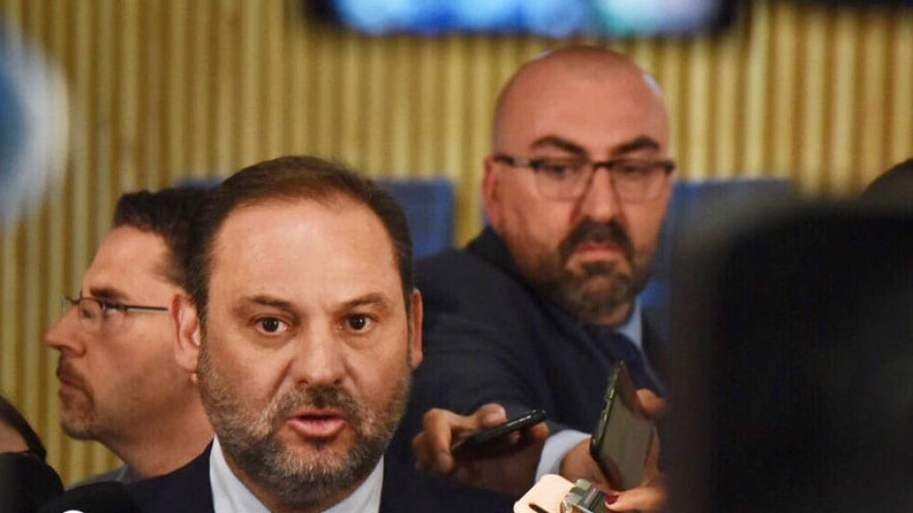 Koldo García Izaguirre, al fondo de la imagen, mientras su entonces jefe, José Luis Ábalos, atiende a la prensa.