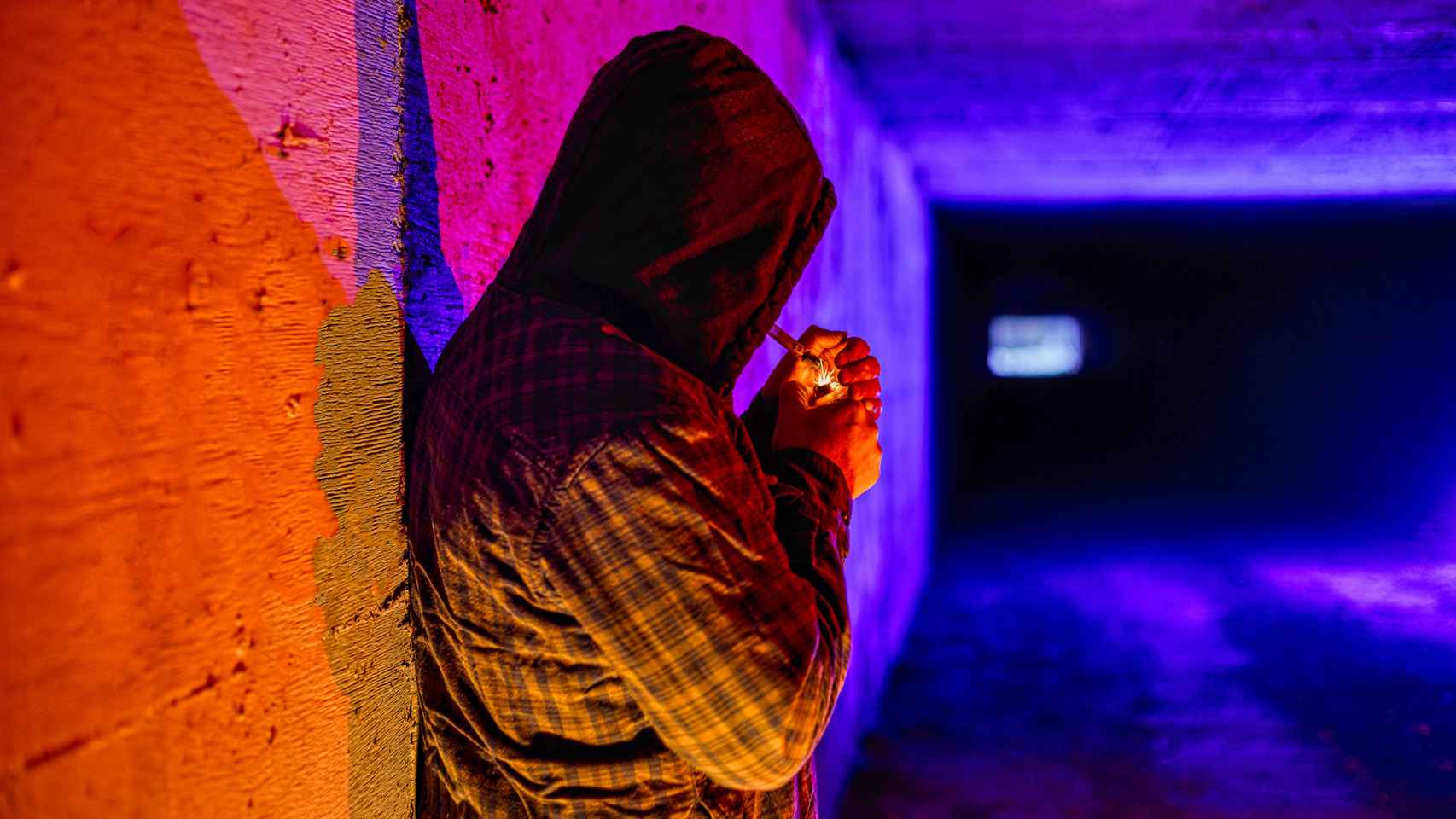 Un hombre se enciende un porro en un túnel.