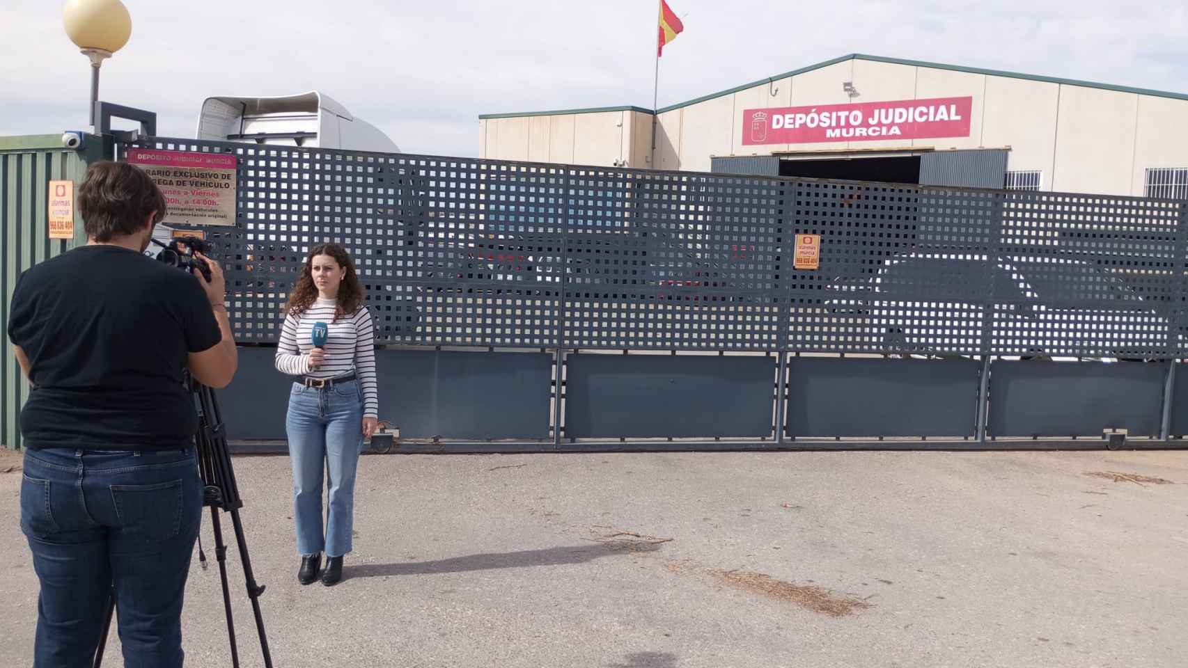 Una periodista de Popular Televisión, este jueves, frente a la sede del Depósito Judicial que administra Rogelio Pujalte Martínez.