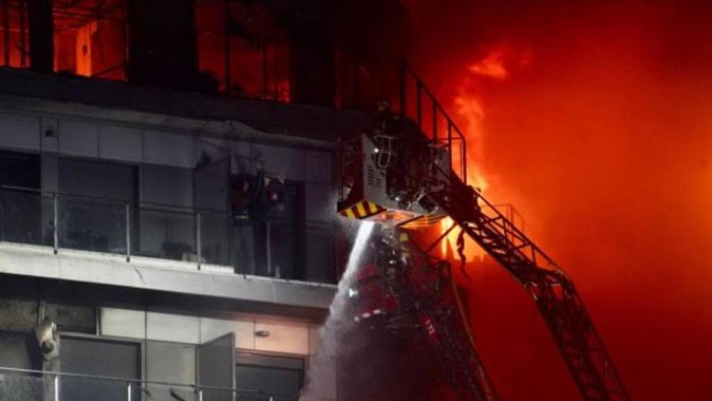 Los bomberos rescatan a dos personas que piden auxilio desde un balcón.