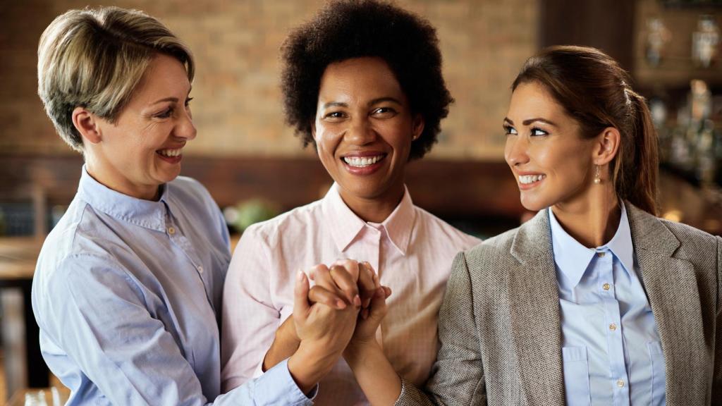 Mujeres trabajadoras felices y apoyándose.