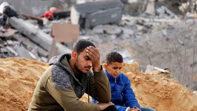 Dos jóvenes sentados tras un ataque israelí contra su casa, hoy en Rafah.
