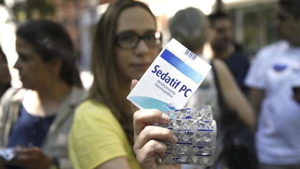 Una activista muestra un tipo de fármaco homeopático.