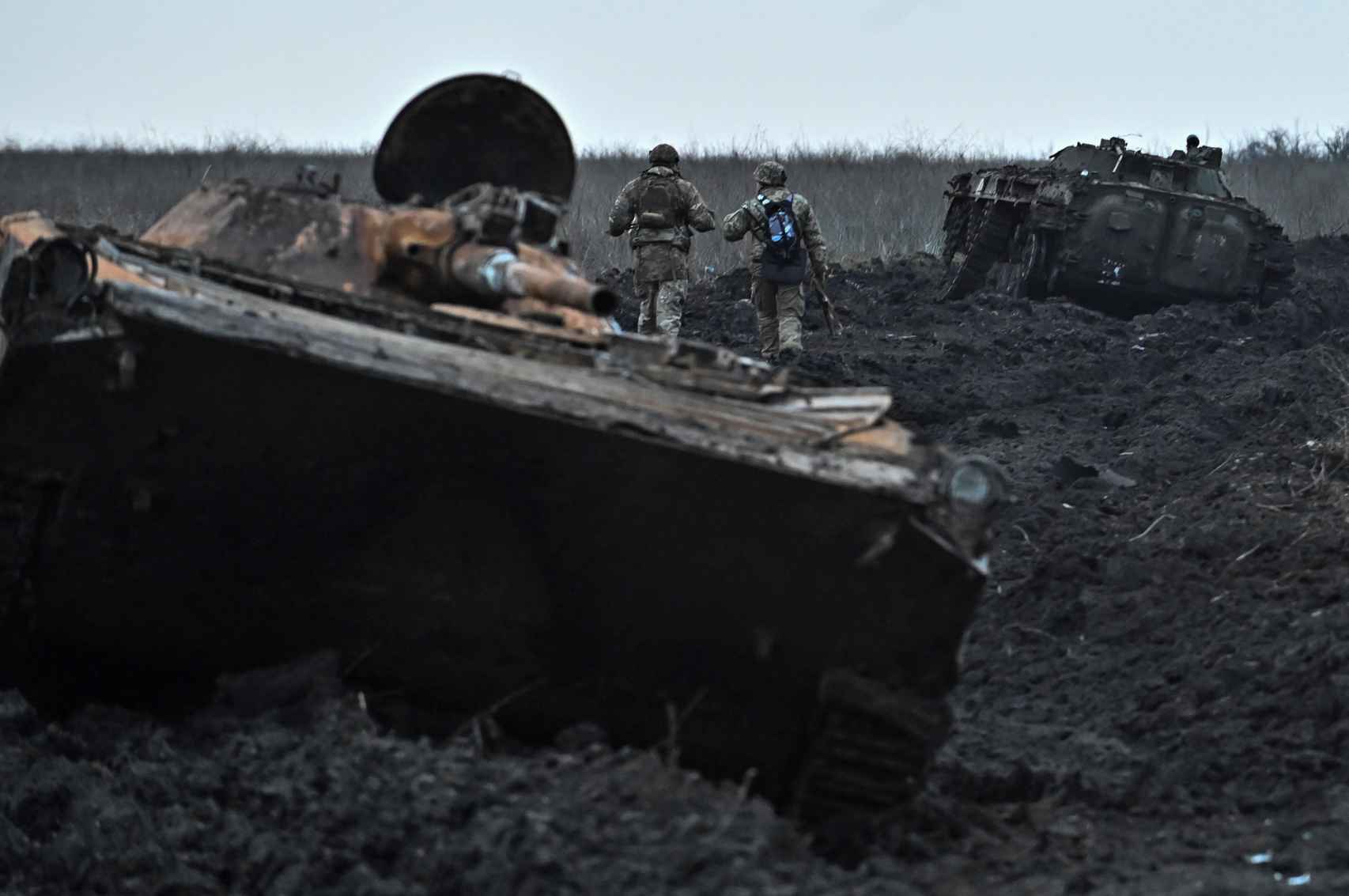 Militares ucranianos caminan junto a vehículos blindados de combate abandonados cerca del pueblo de Robotyne, en primera línea de combate.