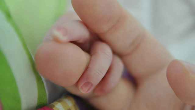 Una madre coge la mano de un recién nacido.