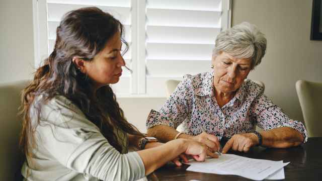 Mujer de avanzada edad revisando documentos con su hija