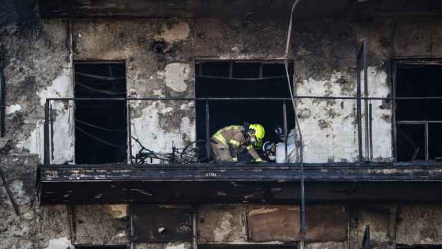 Los bomberos trabajan en los edificios calcinados por las llamas en Valencia