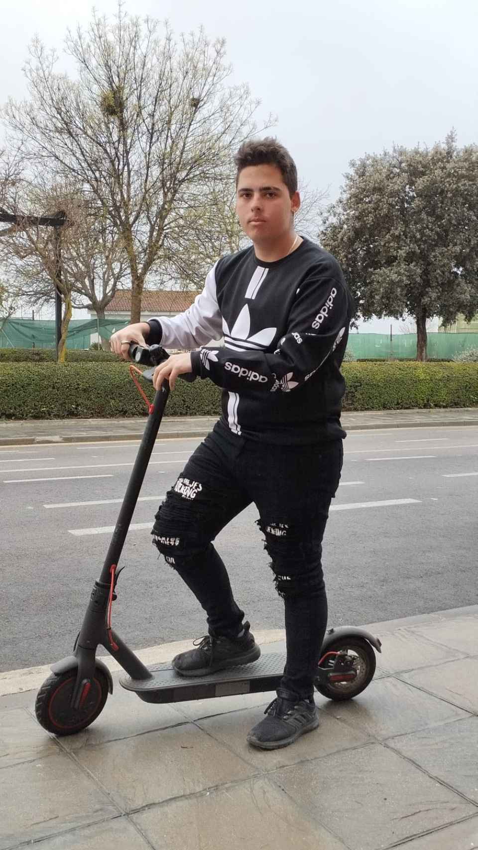 Adrián, posando con el patinete eléctrico en el que sufrió el accidente.
