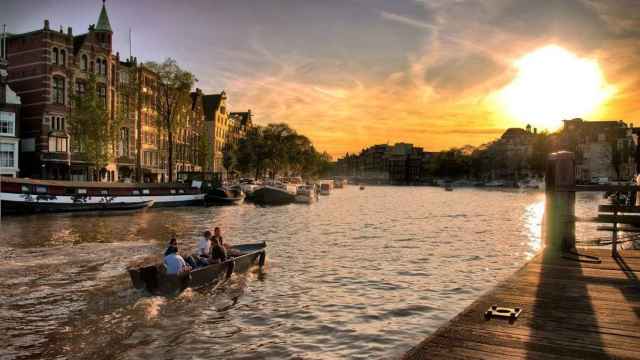 Varias personas navegando por los canales de Ámsterdam