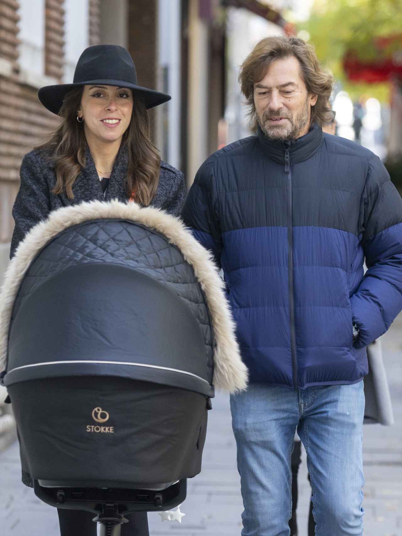 Elena Hormigos y Santiago Pedraz paseando con su hijo en las calles de Madrid.