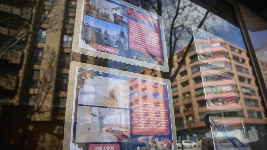 Cartel de una vivienda en venta en el escaparate en el barrio de Almagro.