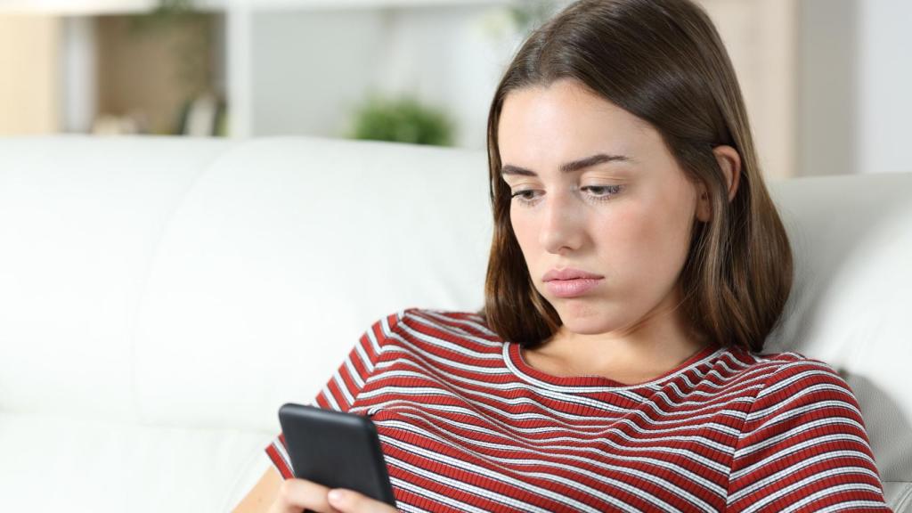 Imagen de una mujer frustrada con su teléfono.