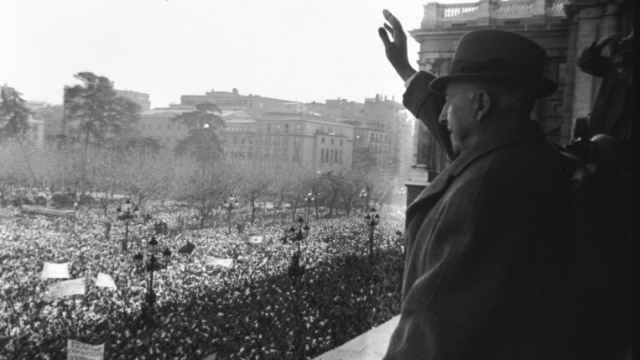 El dictador Franco saludando desde un balcón del Palacio Real durante una manifestación a favor de su régimen.