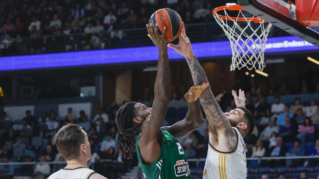 El ala-pívot francés del Panathinaikos Mathias Lessort (c) entra a canasta ante el pívot francés del Real Madrid Vincent Poirier.
