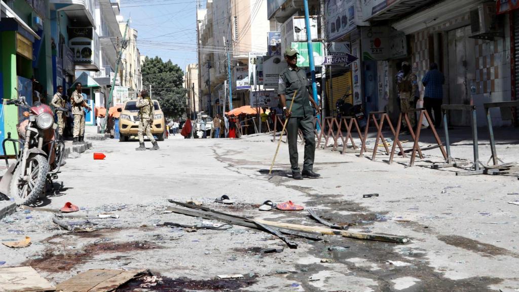 Un oficial de policía somalí está de guardia en la escena después de una explosión en el mercado de Bakara en Mogadiscio en febrero.