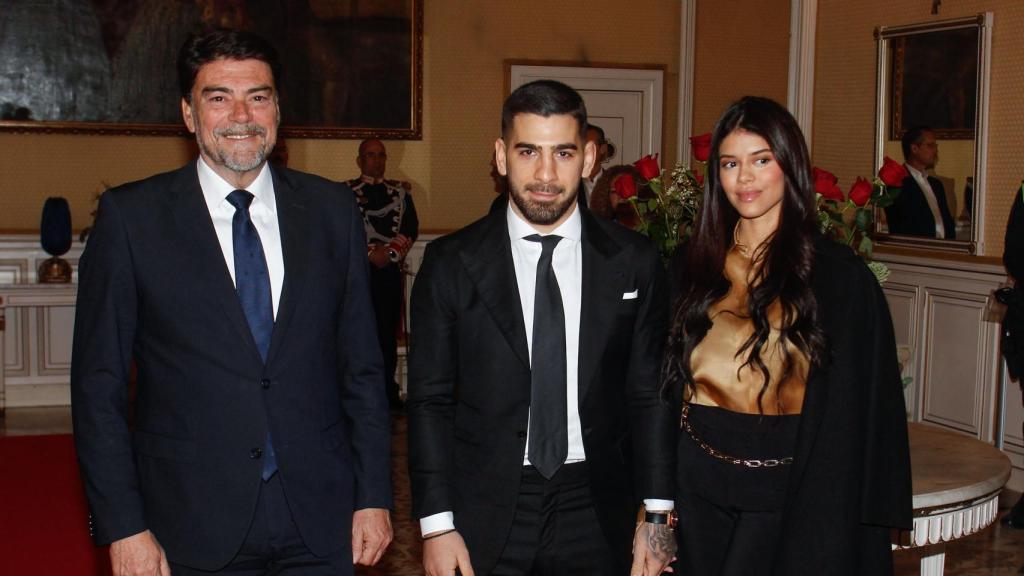 El campeón del mundo de UFC peso pluma, Ilia Topuria(c), acompañado por su pareja, Giorgina Uzcategui y el alcalde de Alicante, Luis Barcala, durante el homenaje que ha recibido hoy viernes en el ayuntamiento de Alicante.