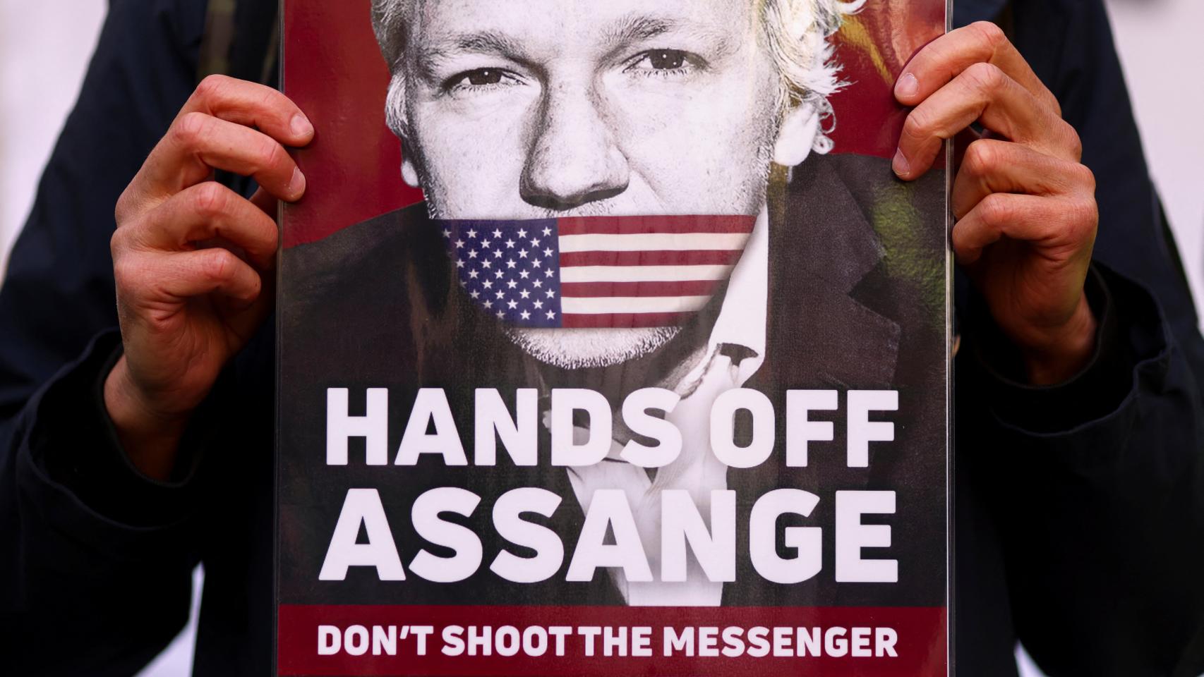 Un activista sostiene un cartel de apoyo a Julian Assange.