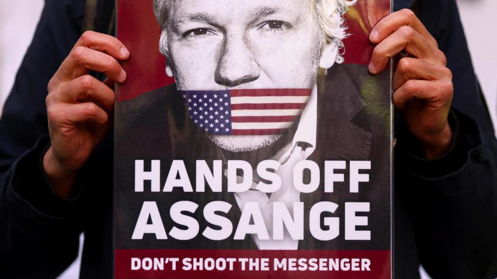 Un activista sostiene un cartel de apoyo a Julian Assange.