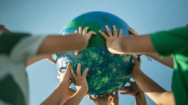 Niños sujetando una maqueta de la Tierra. Getty Images