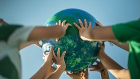 Niños sujetando una maqueta de la Tierra. Getty Images