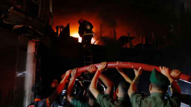 Los bomberos intentan apagar el fuego en un edificio comercial en Dhaka.