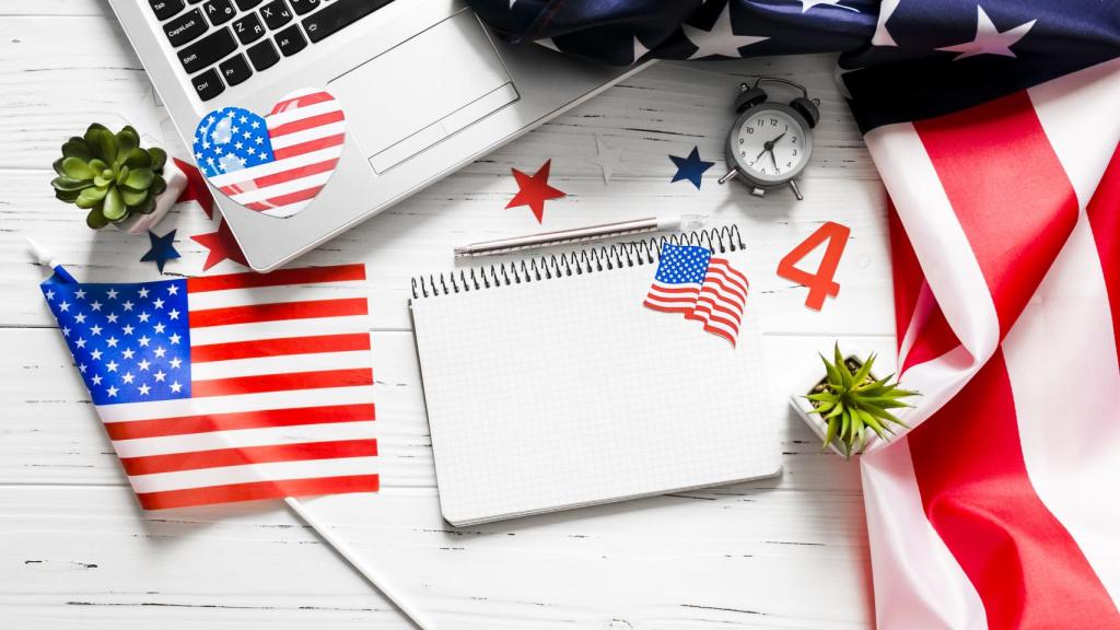 Imagen de una libreta, un ordenador y banderas estadounidenses.