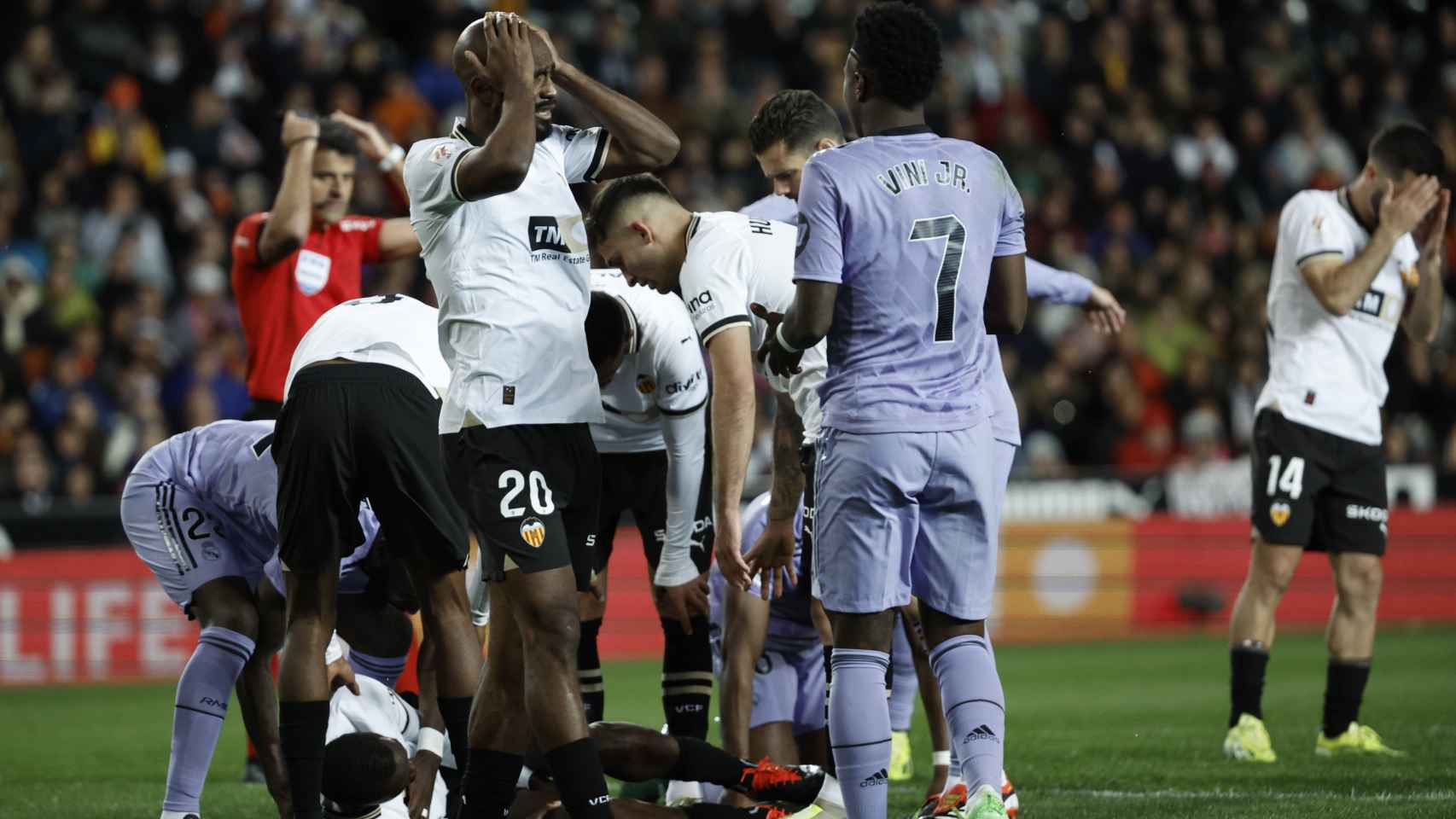 Foulquier y otros jugadores del Valencia se llevan las manos a la cabeza al ver la lesión de Diakhaby.