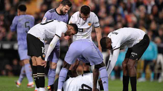 Diakhaby, tendido en el suelo, es atendido por varios jugadores del Real Madrid y del Valencia.