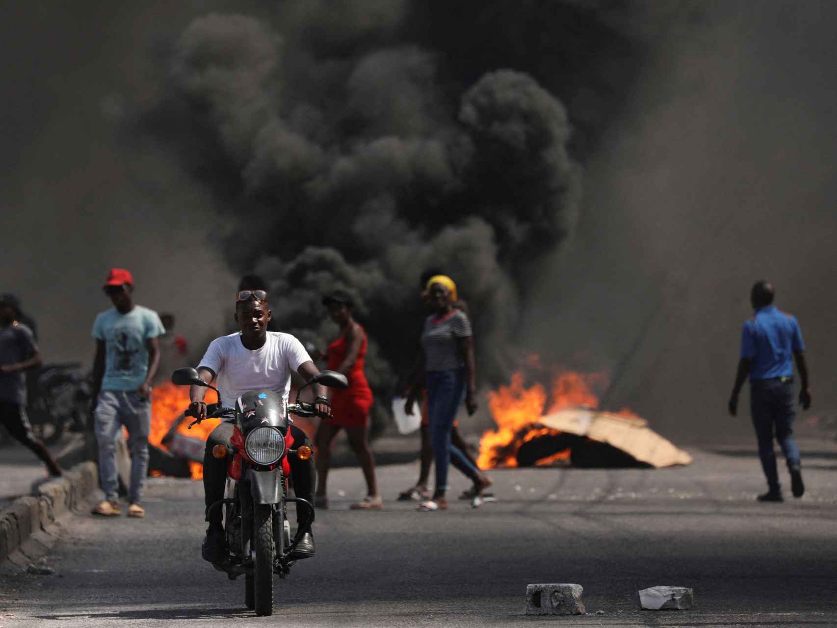 Un hombre avanza en moto en medio de los disturbios en Haití