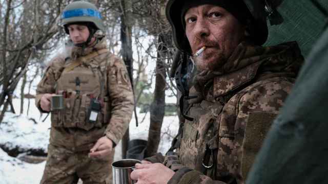 Dos soldados de artillería de la 22 Brigada del Ejercito ucraniano esperan junto a su trinchera en el frente de combate de Bakhmut.