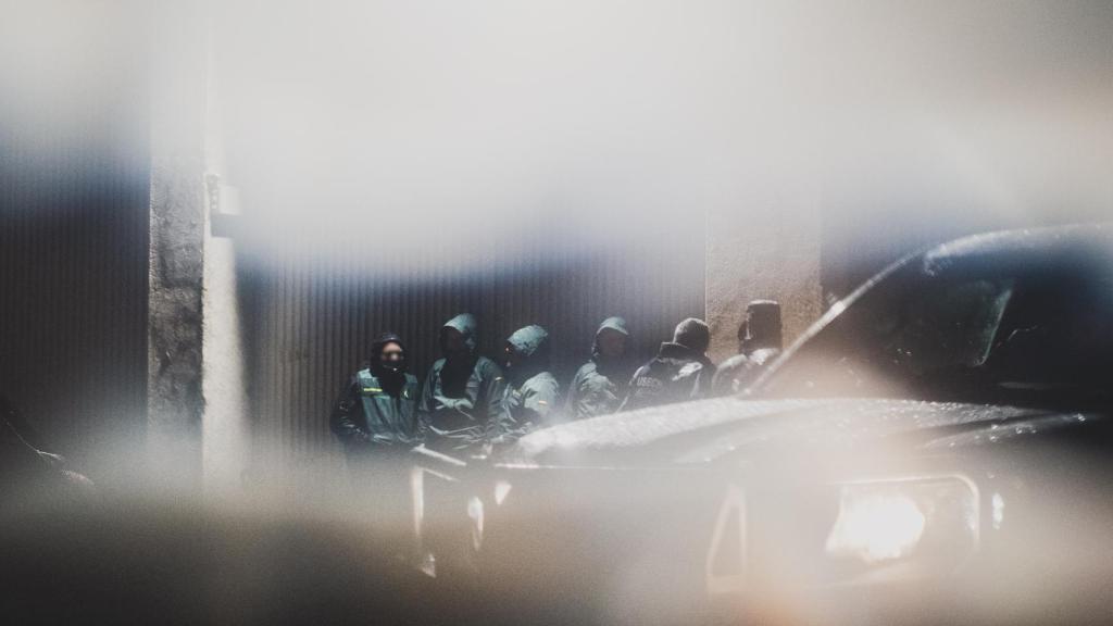 Efectivos de la Guardia Civil se resguardan de la lluvia a la espera del inicio del operativo