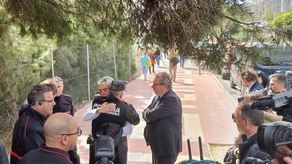 Un policía y un bombero se abrazan horas después del incendio.