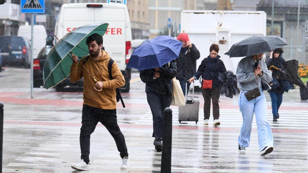 Gente caminando bajo la lluvia.