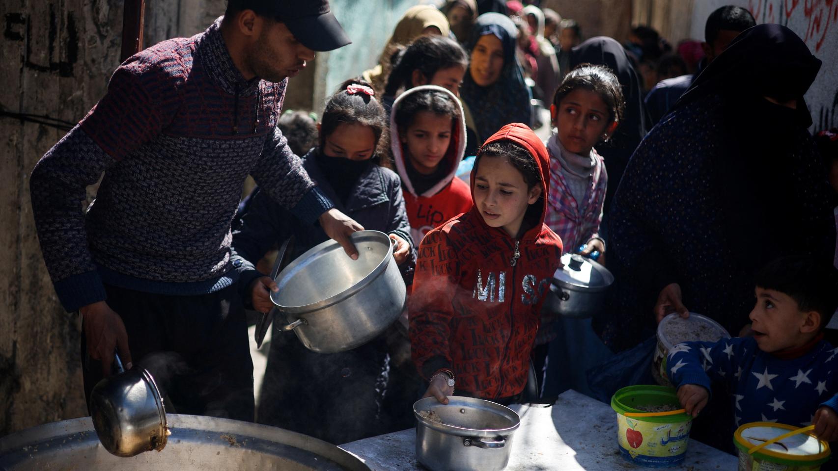 Decenas de civiles esperan a recibir alimento en Rafah.