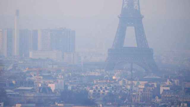 Imagen de archivo de la torre Eiffel rodeada de partículas contaminantes.