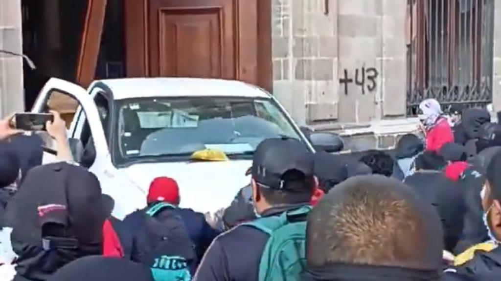 Instante en el que una camioneta carga marcha atrás contra una puerta de entrada al Palacio Presidencial.