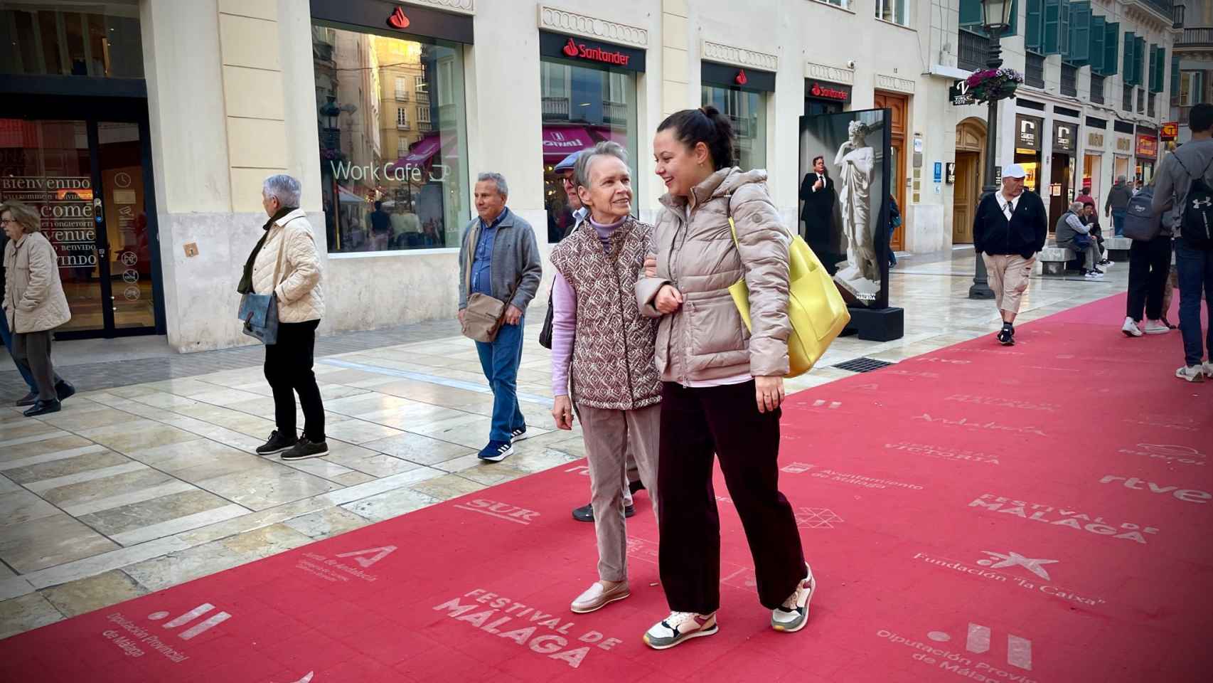 Nadia y su nieta caminando por calle Larios.