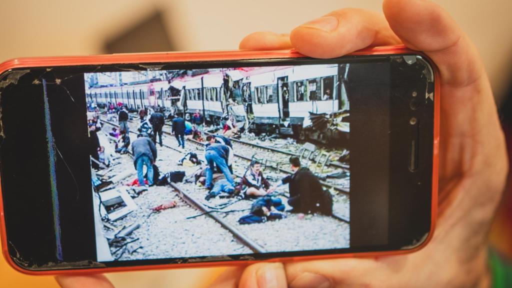En esta foto, se ve a Ángeles, con pantalones rosas, sentada en la vía, auxiliada por su vecino.